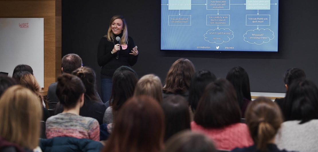 Holly gestures towards group in front of flow chart on effectively preparing for year-end performance reviews