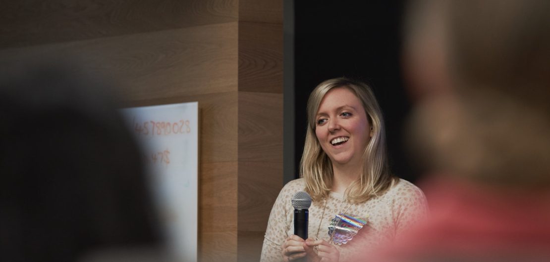 Holly smiles to group during talk on how women undercut their brilliance at work