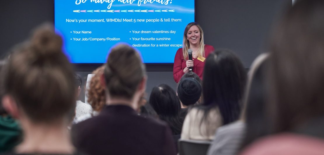 Holly smiles in front of group after talk on dealing with imposter syndrome