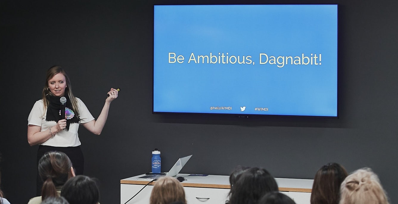 Holly stands in front of screen encouraging audience to "be ambitious!" | by Vancouver photographer Angela McConnell