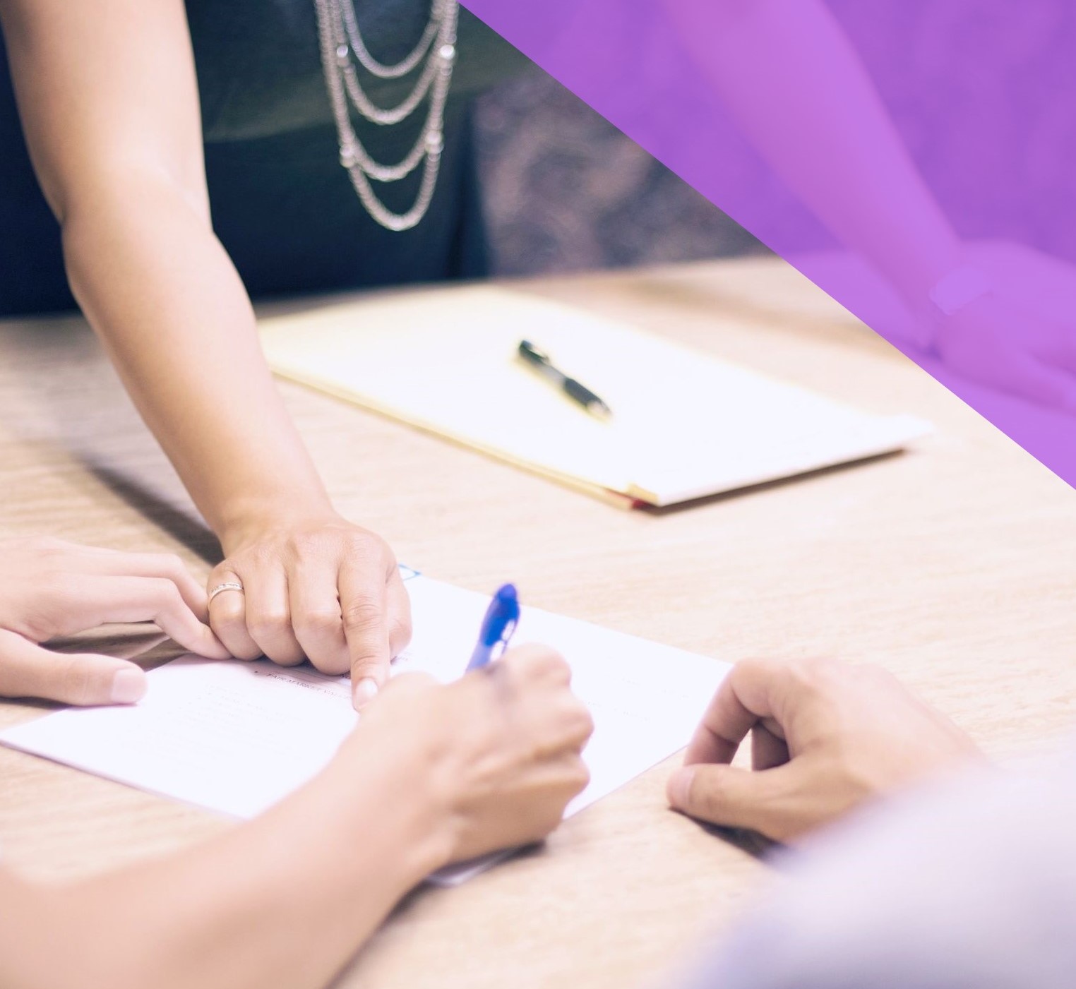 Woman points at a resume held by a colleague | diversity consultant