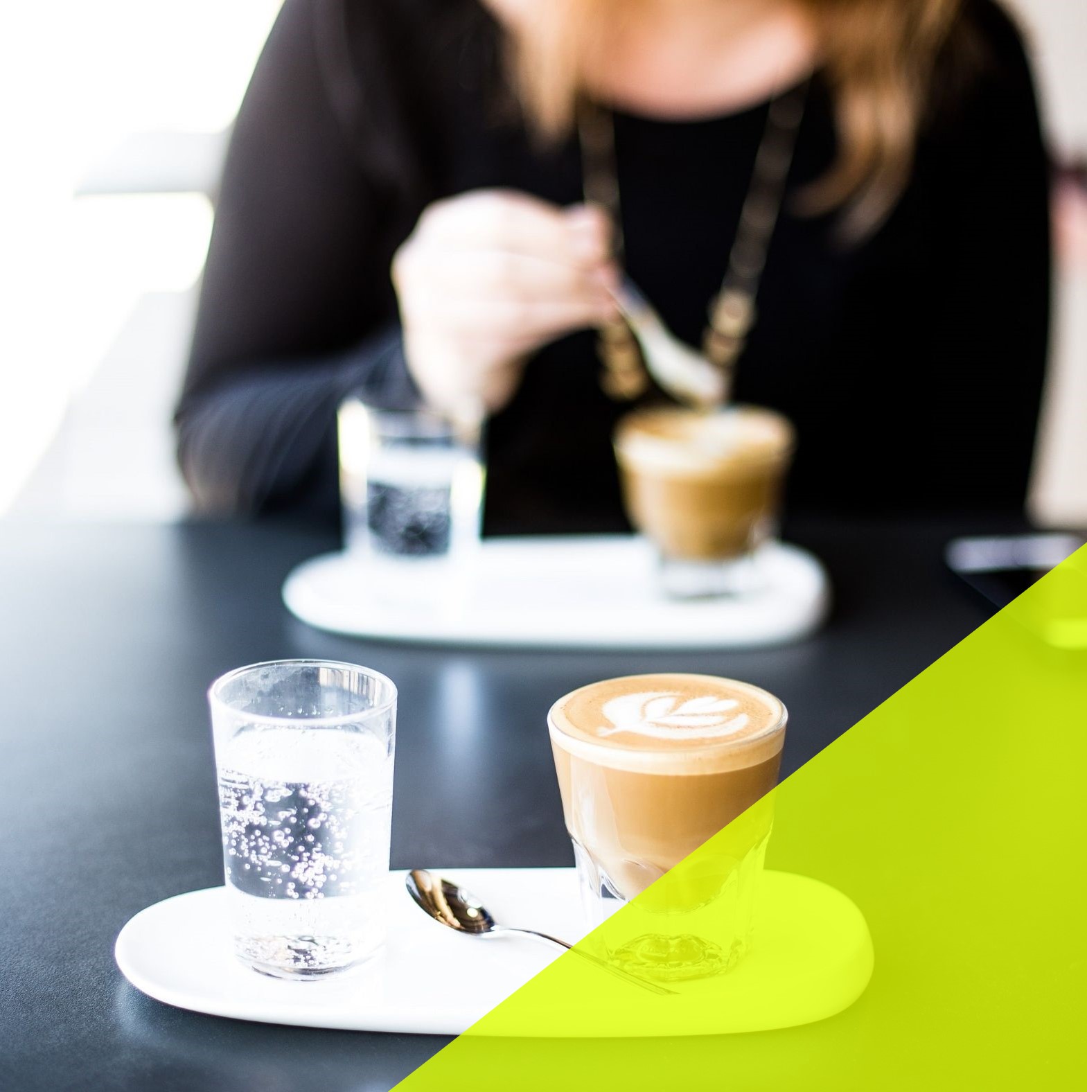 Woman sits across the table with a latte